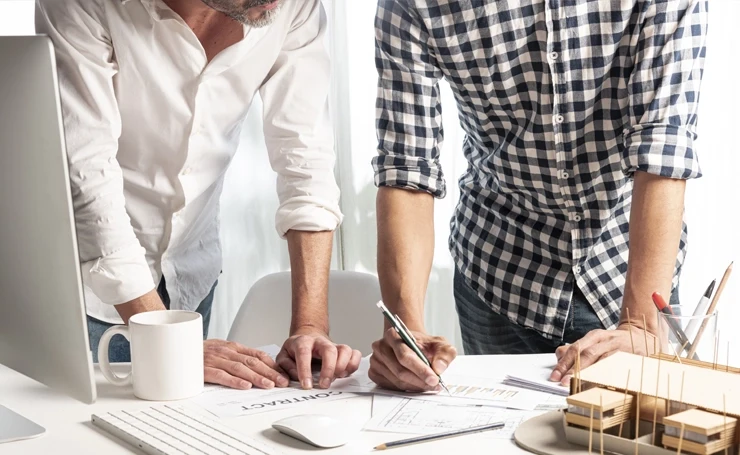 Dos profesionales colaborando en la planificación de proyectos sostenibles.