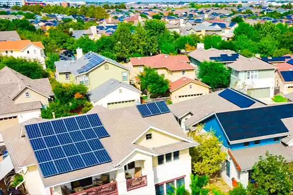 Vue aérienne d'un quartier résidentiel avec des panneaux solaires installés sur les toits.
