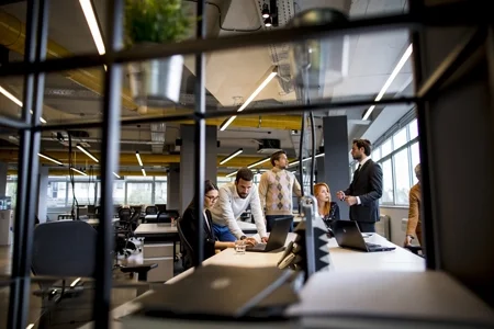 Équipe de professionnels collaborant dans un bureau moderne, axée sur le financement de projets durables.