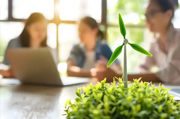 Impulsando las finanzas verdes a través de la colaboración inteligente. Mini turbina eólica sobre una planta verde con profesionales de negocios colaborando al fondo.