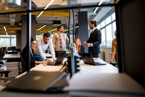 Equipo colaborando en una oficina moderna centrada en prácticas empresariales sostenibles.