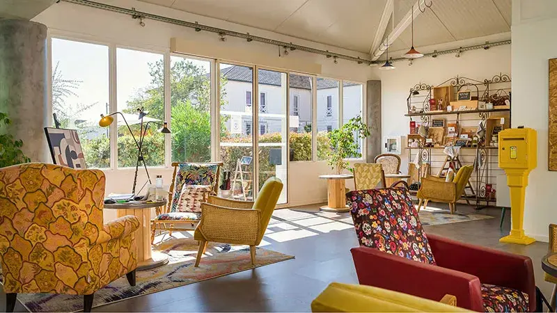 Salon d’accueil coloré et convivial du Greet Hotel Bordeaux Aéroport avec mobilier recyclé.